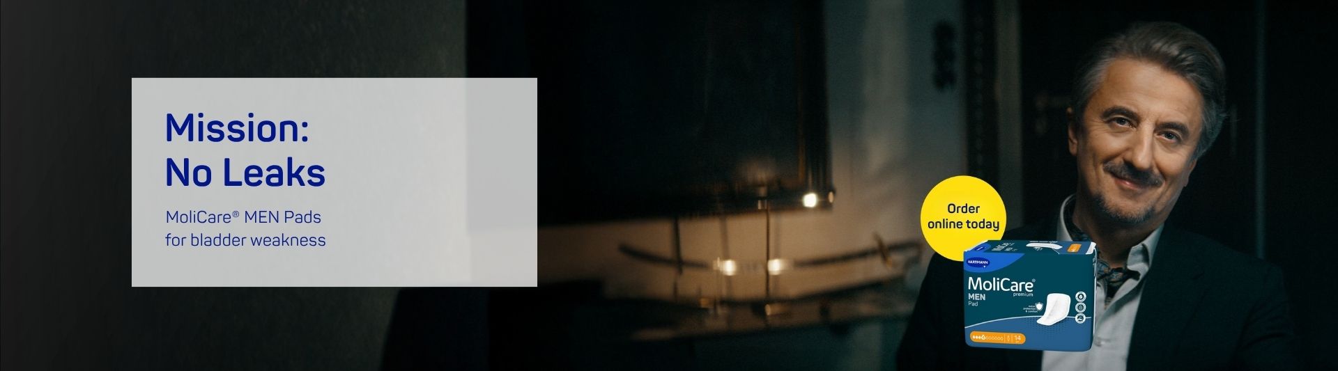 Older man with greying hair and a moustache in a dark blue suit and grey shirt