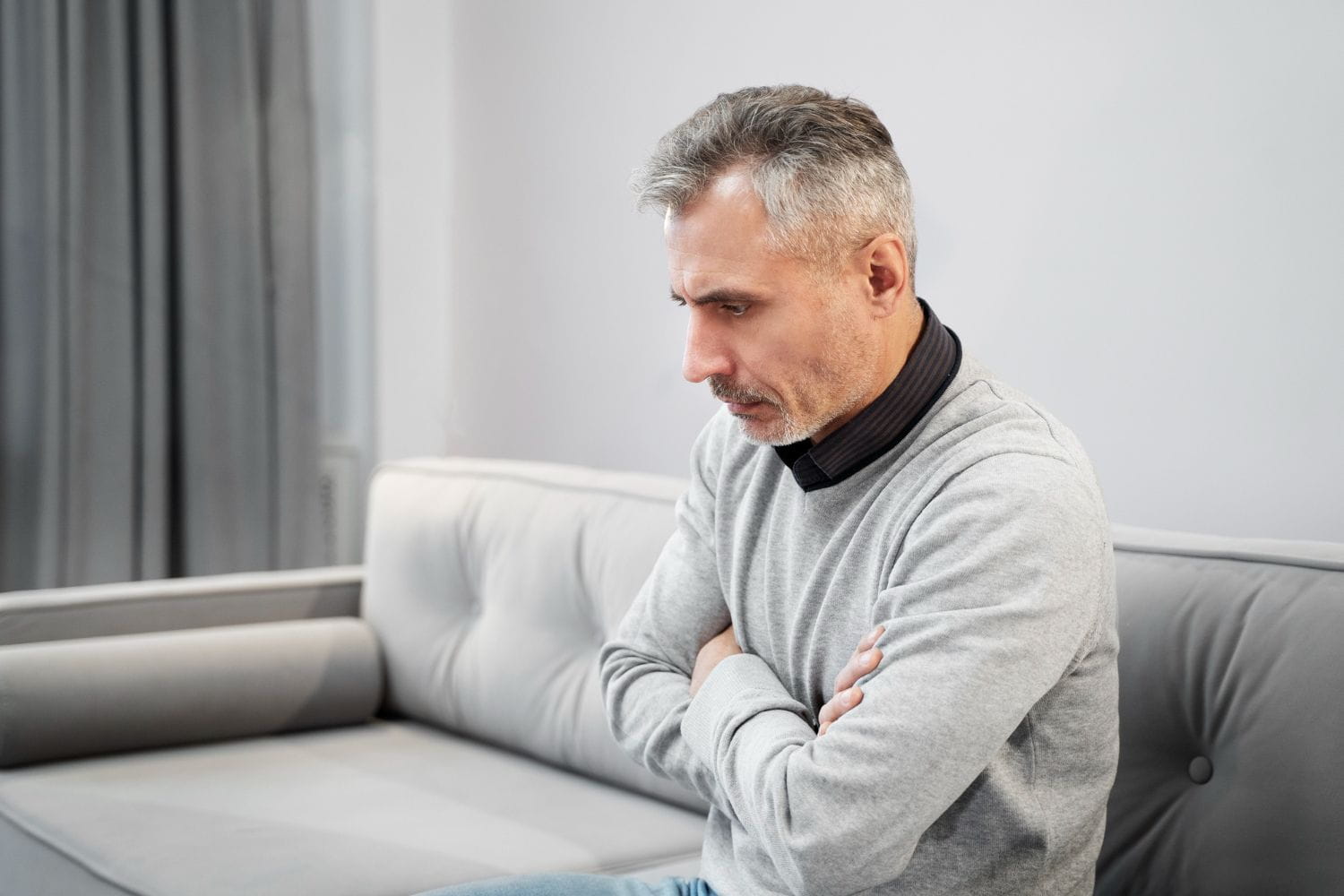 Man sitting at home reflecting on managing bladder leaks