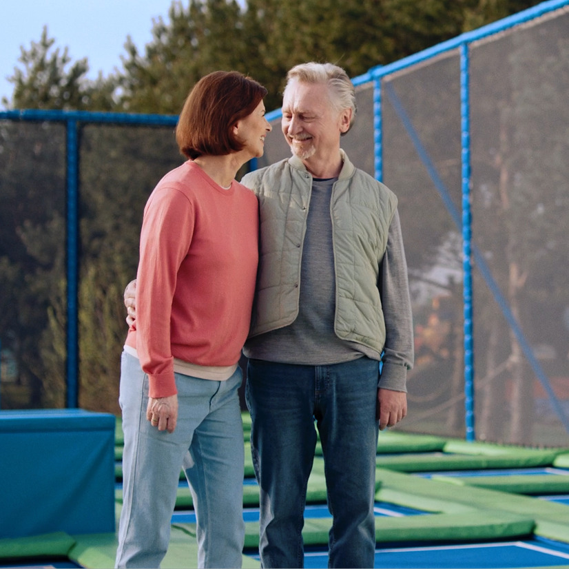 Older couple at a trampoline park gazing lovingly at each other
