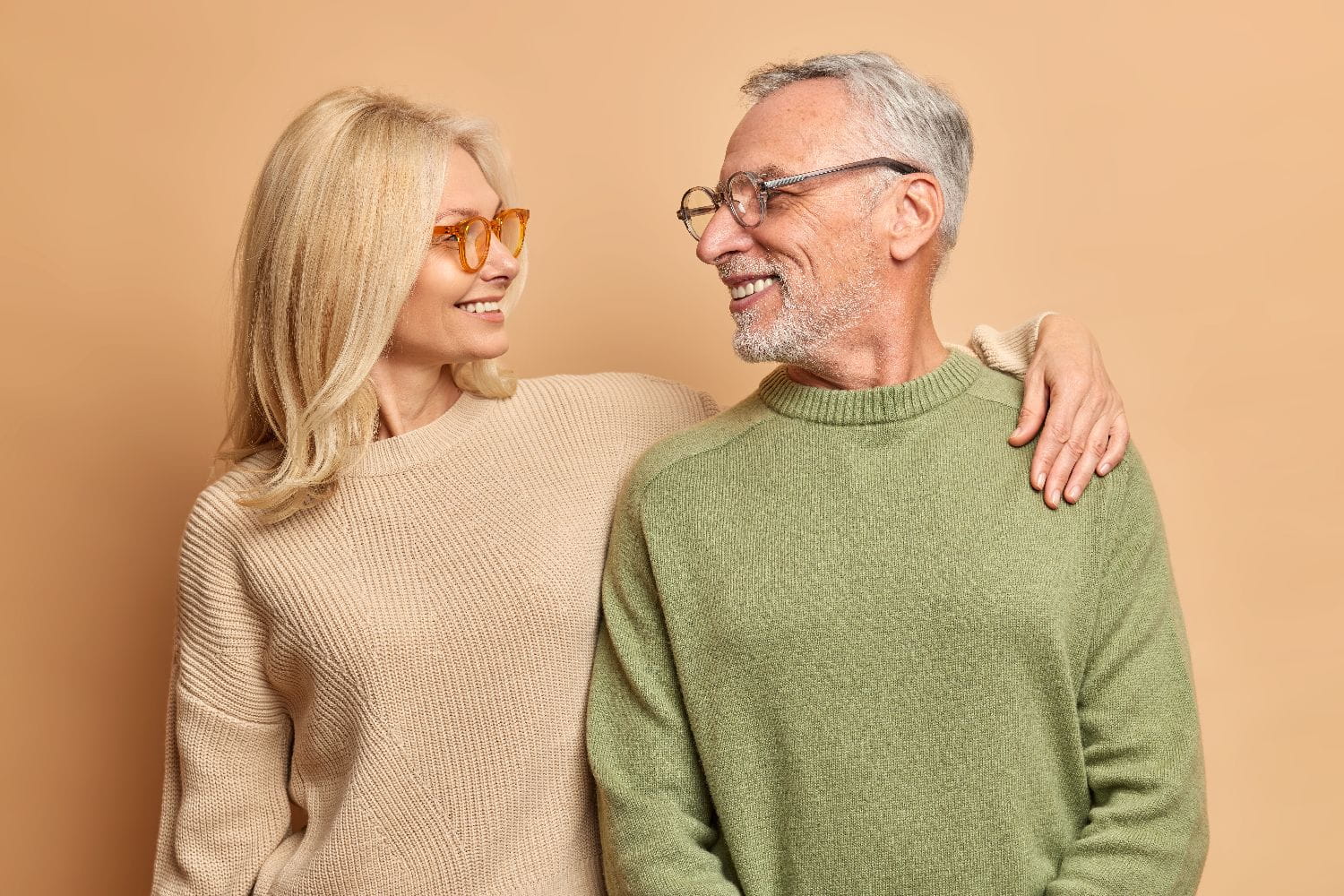 Mature man and woman smiling together while discussing incontinence support