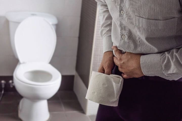 man holding tissue paper with constipation