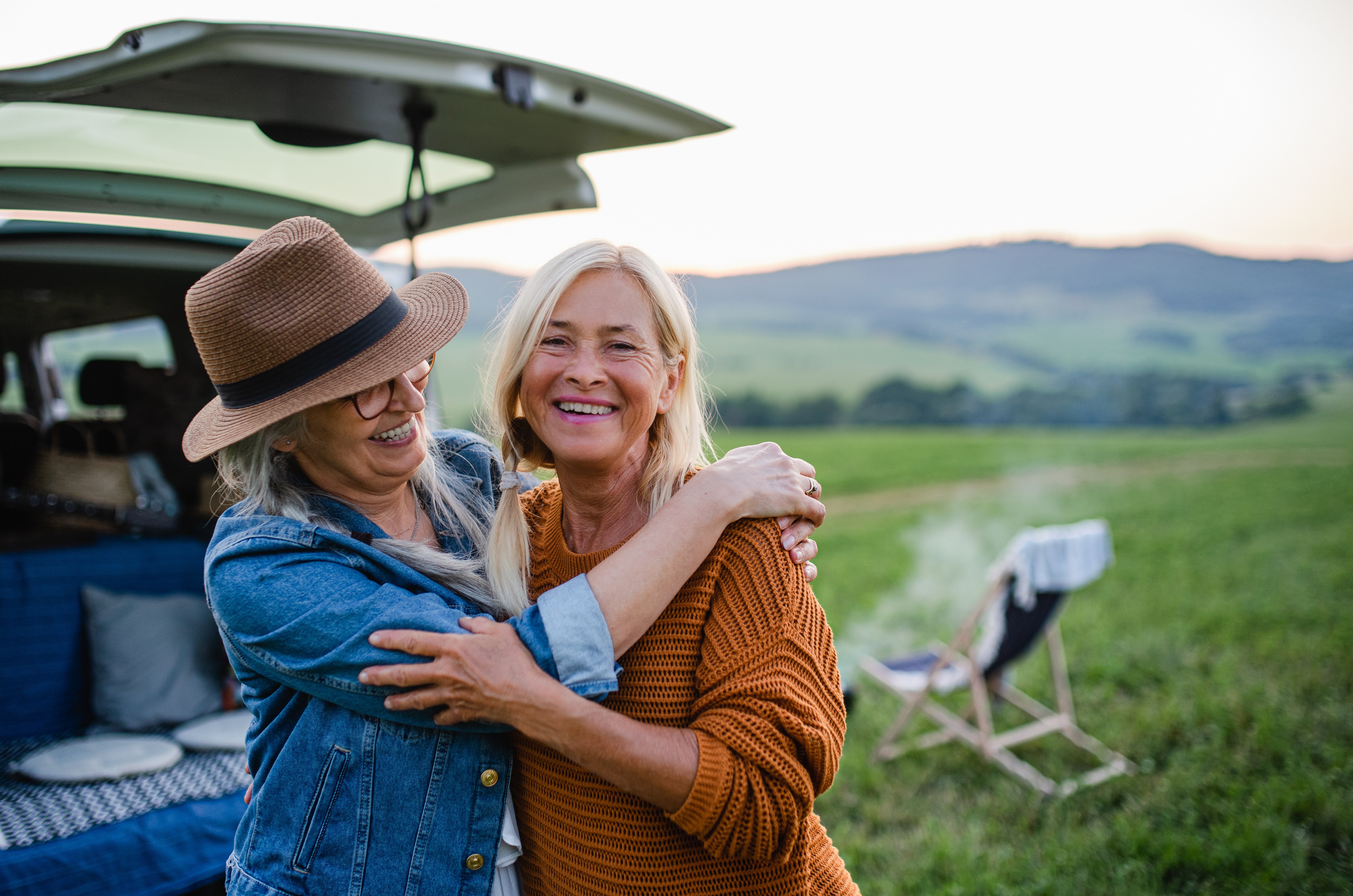 Two Women Hugging While Camping